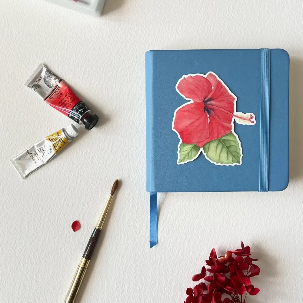 Red hibiscus vinyl sticker on notebook