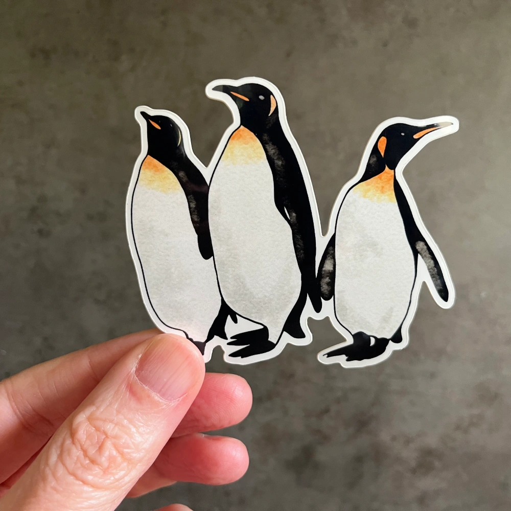 Watercolor King Penguins vinyl sticker held in hand