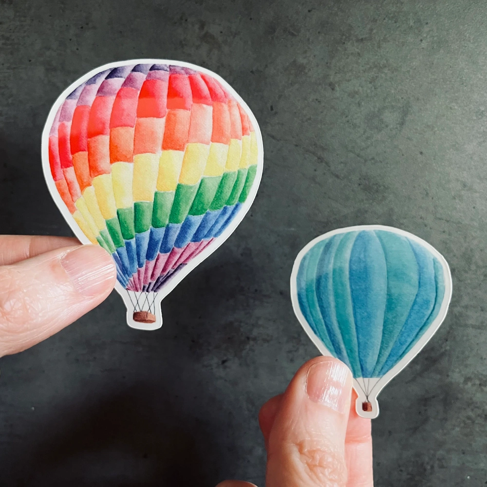 Blue and colorful LGBT balloons set vinyl stickers held in hand